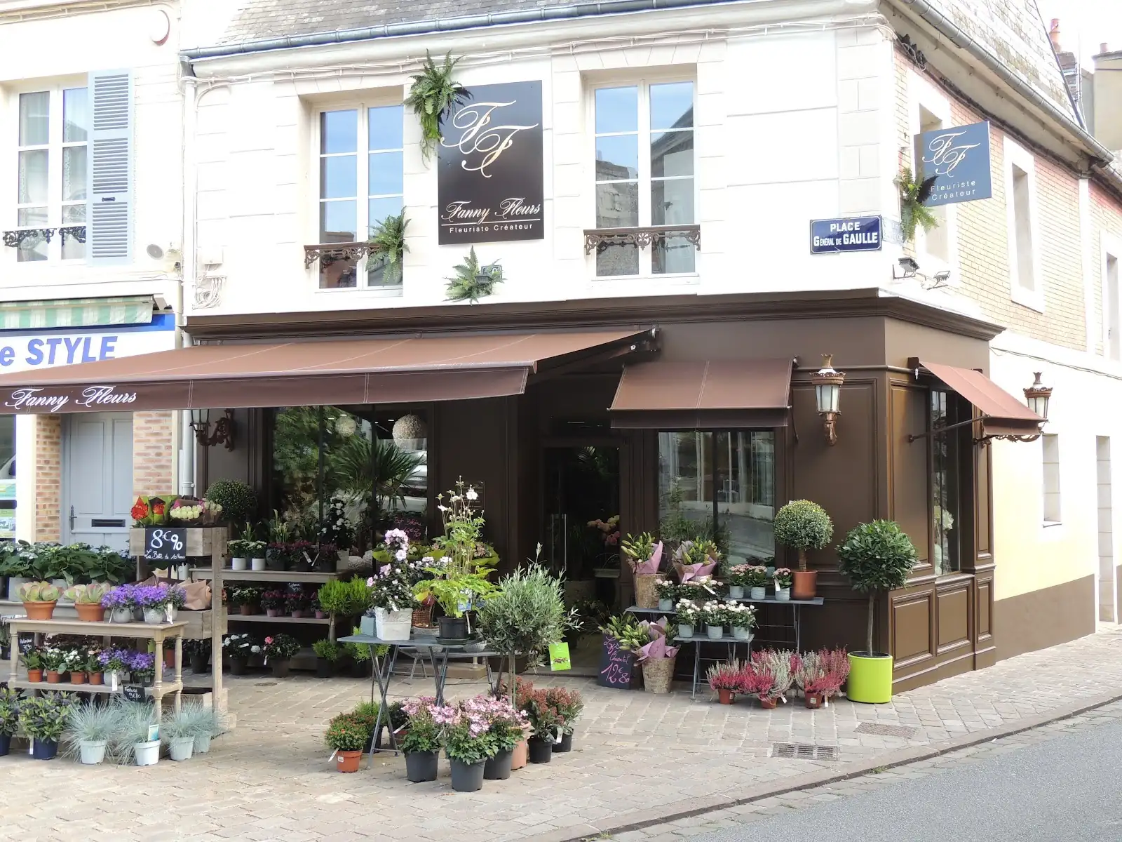 Boutique d’angle et plantes exposées devant les vitrines