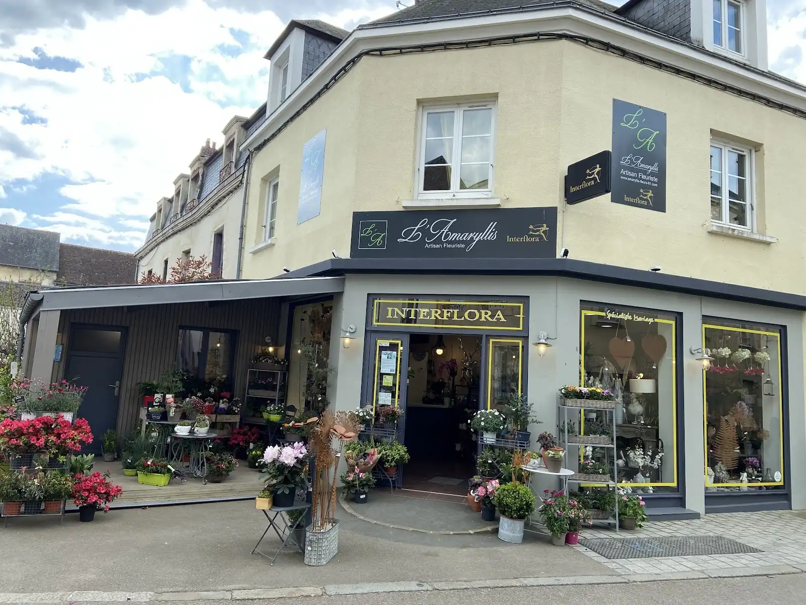 Boutique d’angle avec plantes et fleurs exposées devant les vitrines