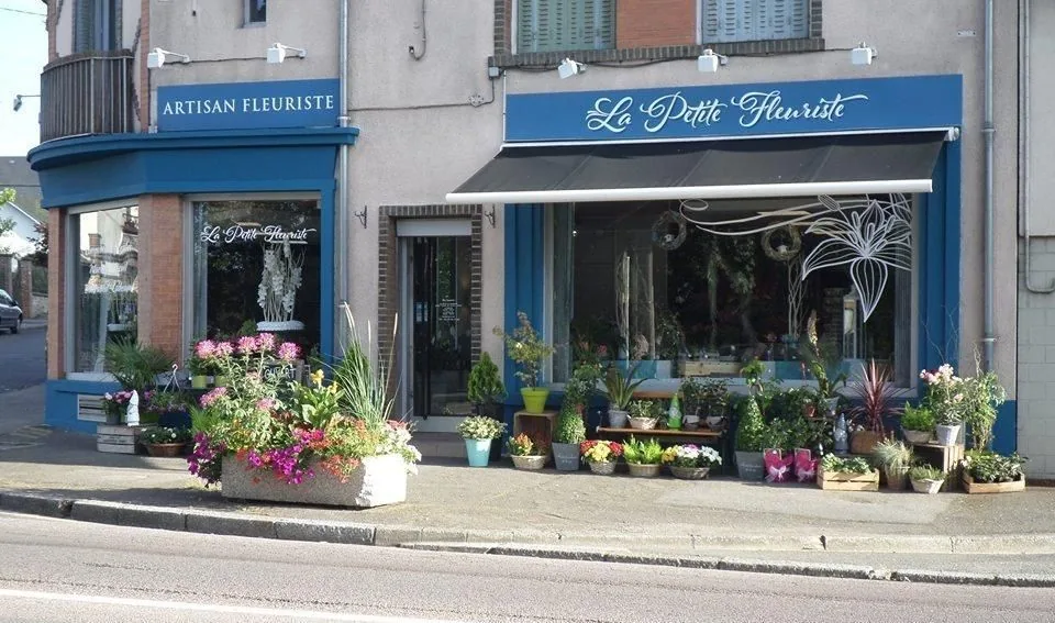 Façade bleue de la boutique et plantes devant la vitrine