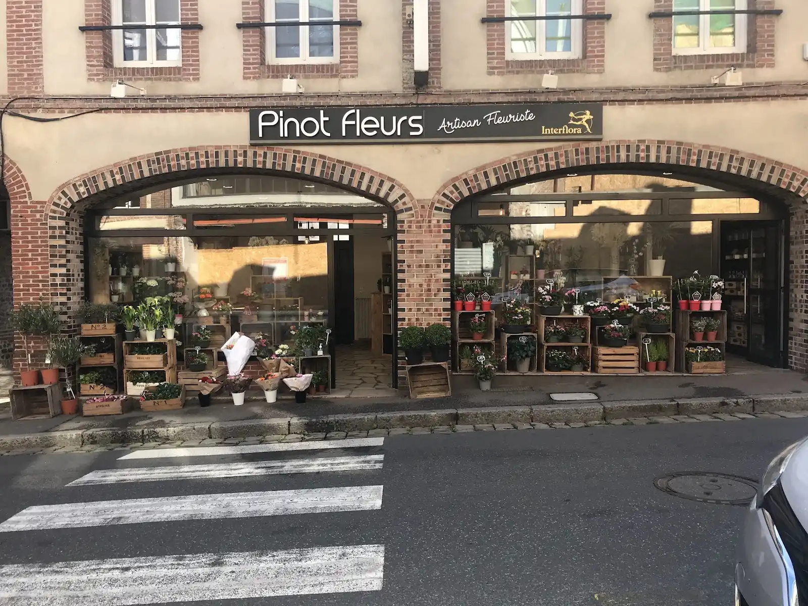 Façade en briques de la boutique et fleurs exposées sur le trottoir